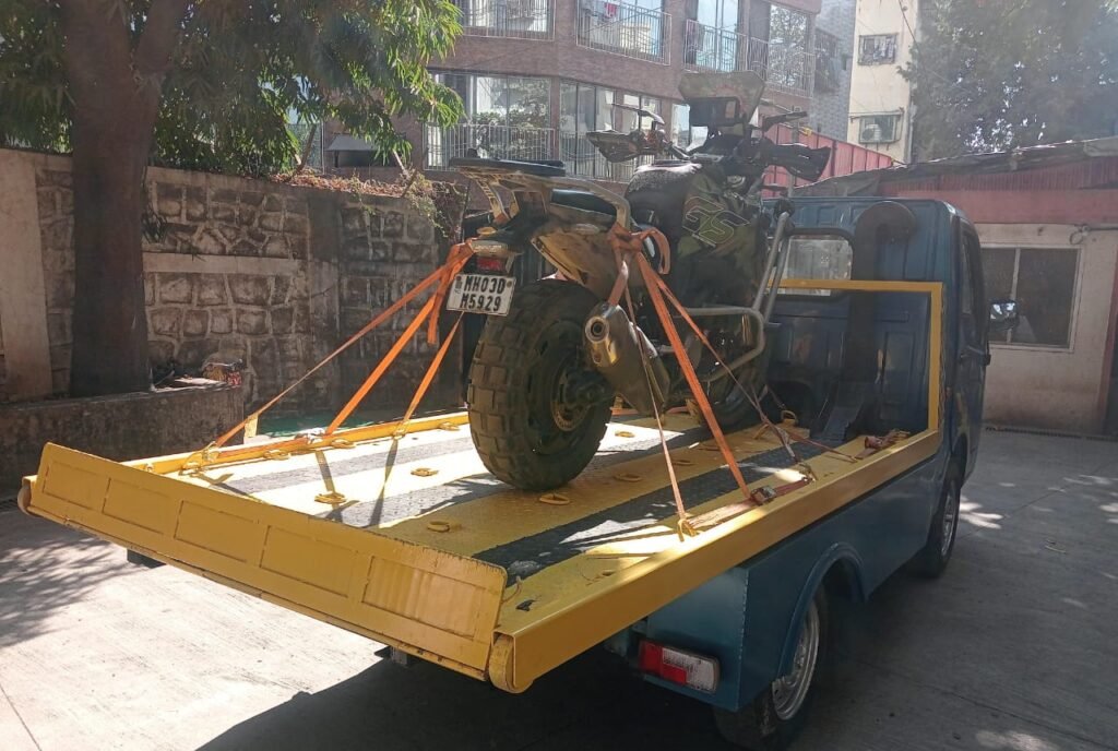 BMW GS adventure bike secured on hydraulic tow truck during transport to Vakola